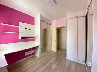 Quarto interno com paredes rosa e armários brancos.