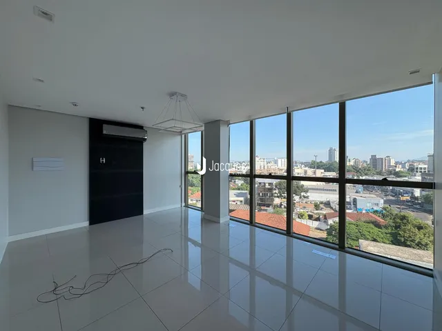 Sala ampla com vista panorâmica da cidade através de grandes janelas.