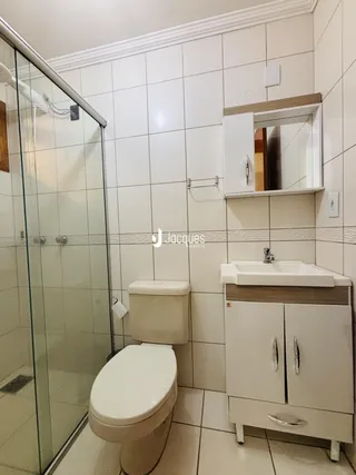 Foto de um banheiro com piso de cerâmica e box de vidro.