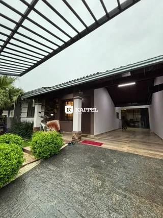 Fachada de uma residência em Lajeado, Brasil, mostrando a área externa pavimentada e vegetação.