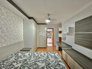 Quarto com paredes decoradas e armários embutidos de madeira.