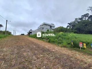 Vista externa de uma residência em Lajeado, Brasil, com paisagem verde ao redor.