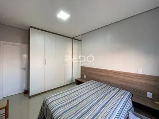 Quarto com armários embutidos e cabeceira de madeira.