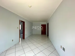 Corredor interno de uma residência com piso de cerâmica branca.