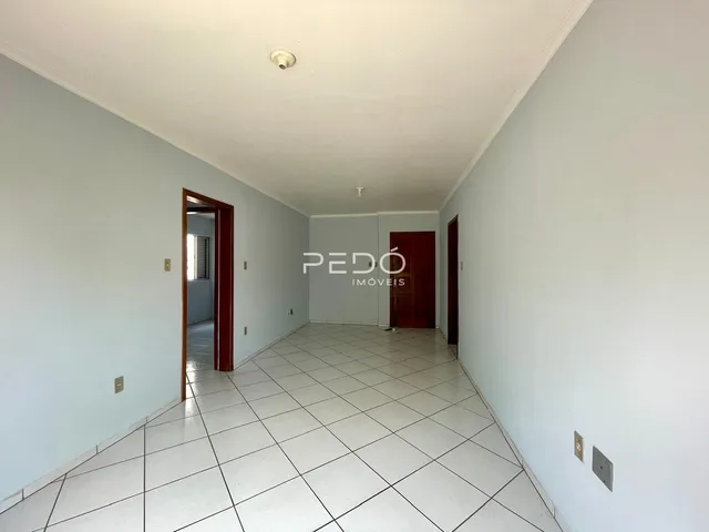 Corredor interno de uma residência com piso de cerâmica branca.