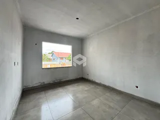 Interior de uma sala com paredes brancas e piso de cerâmica.