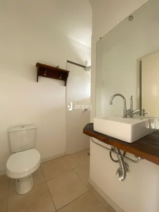Foto de um banheiro com piso de cerâmica e paredes brancas em uma residência.