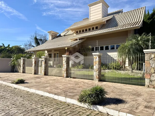Fachada de uma residência em Lajeado, Brasil, com cerca e paisagismo.