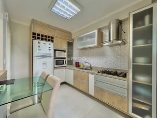 Cozinha moderna com armários de madeira e bancada clara.
