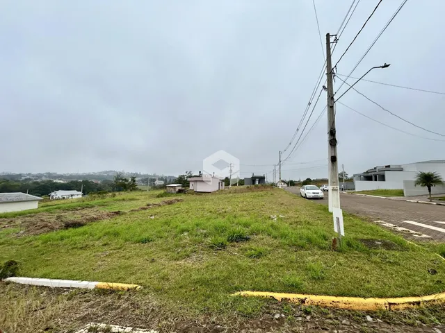 Vista aérea de uma área gramada com terreno aberto e postes de luz.