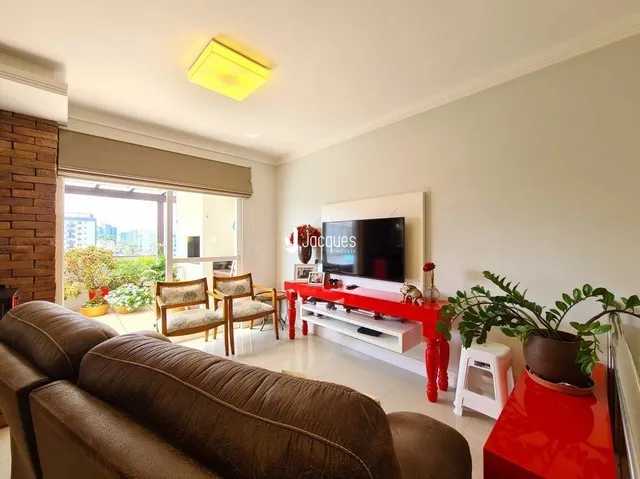 Uma sala de estar com sofá marrom e parede de madeira.