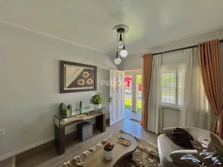 Sala de estar com sofá e decoração de madeira em Lajeado.