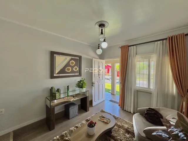 Sala de estar com sofá e decoração de madeira em Lajeado.