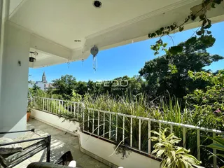 Vista da varanda com vegetação exuberante e vista para a natureza.