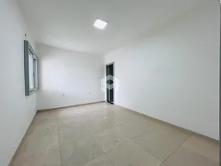 Interior de uma sala com paredes brancas e piso de cerâmica clara.
