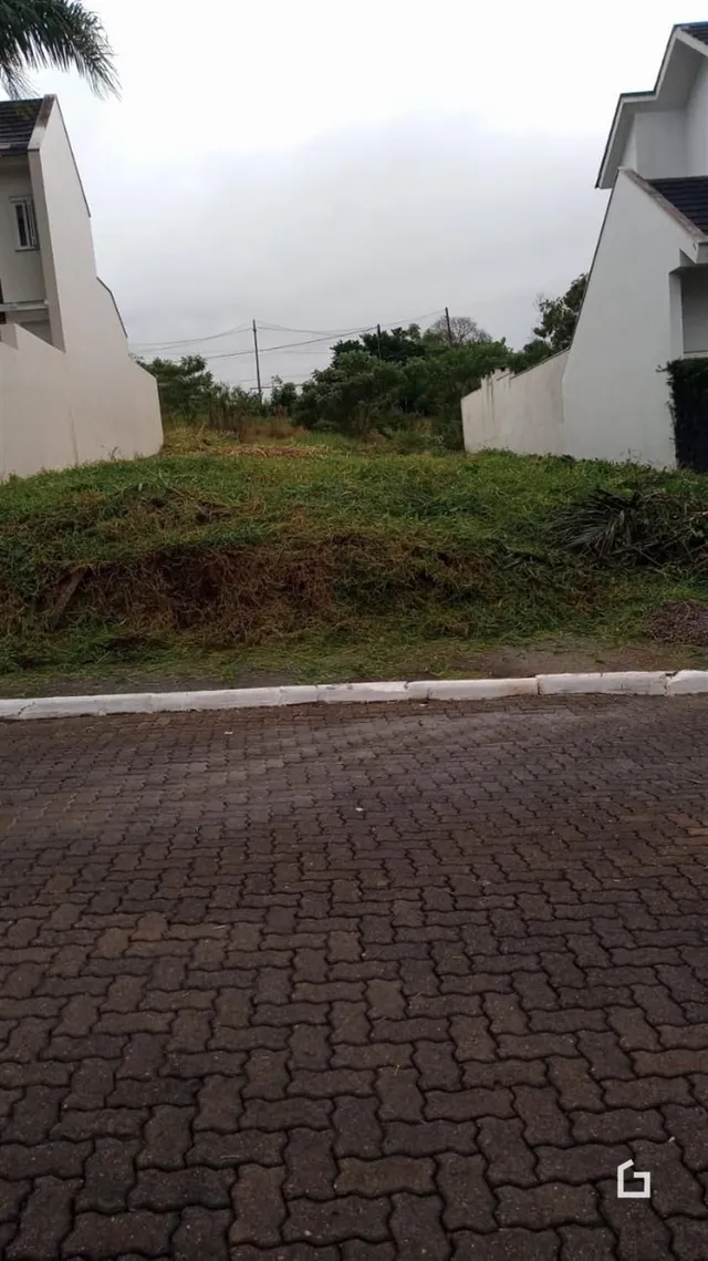Fachada de uma residência com área gramada e pavimento na frente