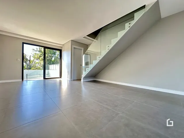 Sala de estar ampla com piso de concreto e porta de vidro.