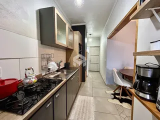 Foto de uma cozinha com armários de madeira e bancada em Lajeado, Brasil.
