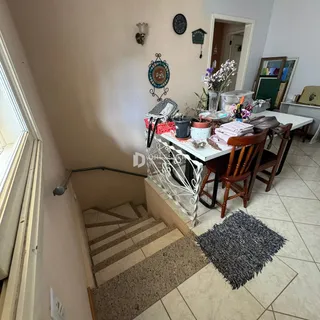 Vista de um corredor com acesso a uma área de jantar em uma residência.