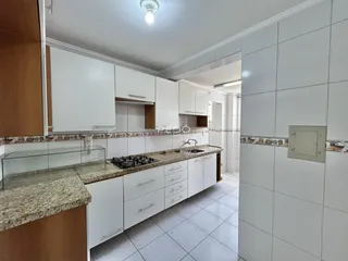 Cozinha moderna com armários brancos e bancadas de granito.