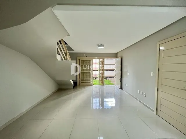Corredor interno de uma residência com piso de cerâmica claro.