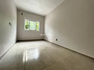Vista interna de um cômodo com paredes brancas e piso claro.