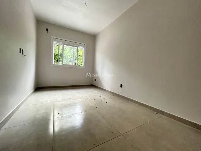 Vista interna de um cômodo com paredes brancas e piso claro.