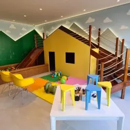 Sala de estar com paredes verdes e escadaria de madeira.