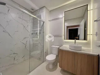 Foto de um banheiro moderno com revestimento de mármore e box de vidro.