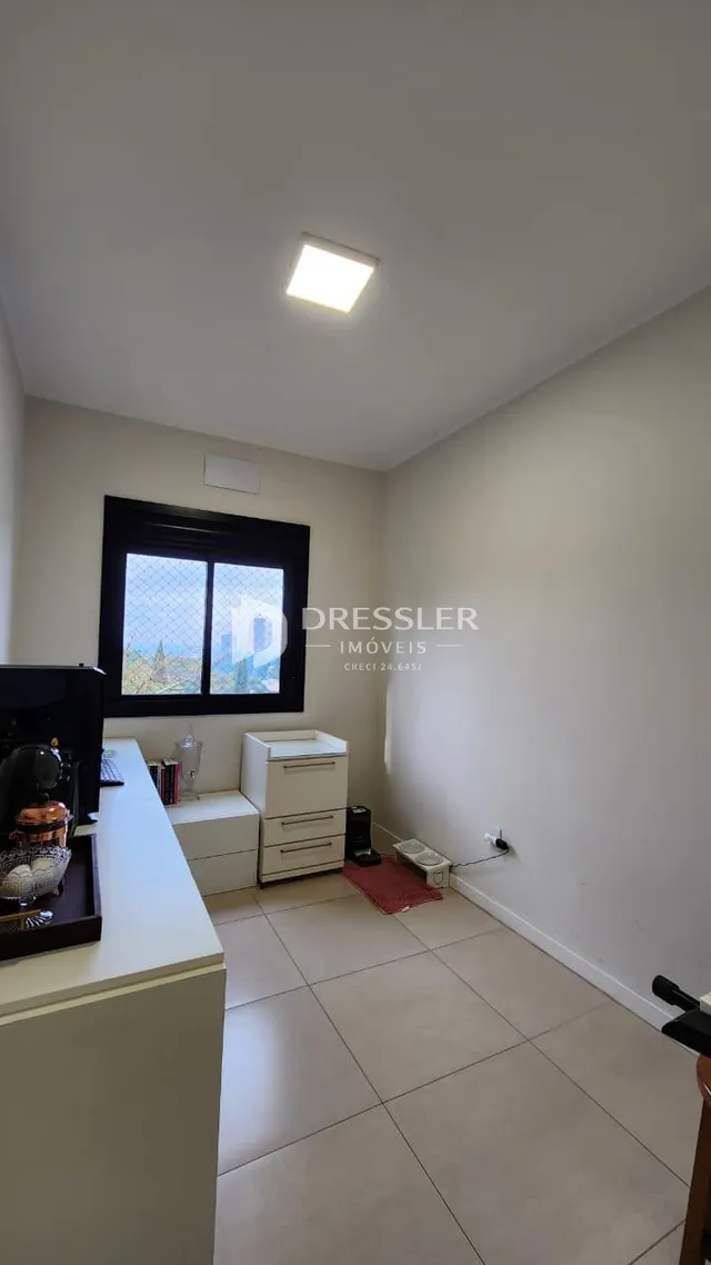 Ambiente interno de uma sala com piso de cerâmica e janela.