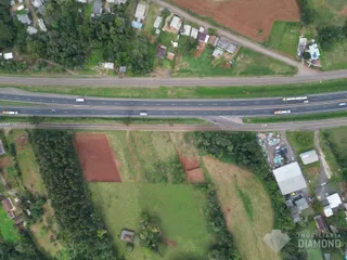 Vista aérea de uma propriedade rural com campos e estradas no Brasil.