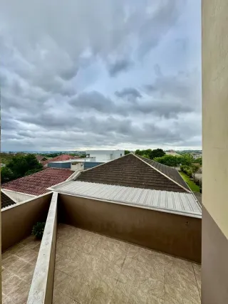 Vista da área externa do imóvel com telhado visível.