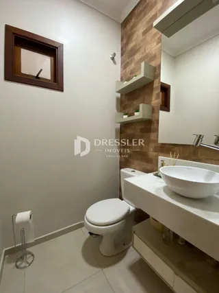 Foto de um banheiro interno com vaso sanitário e pia brancos.