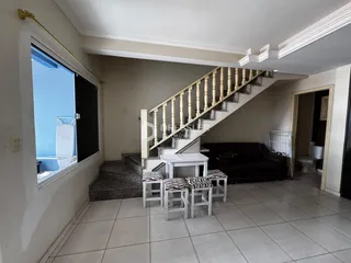Sala de estar com escadaria e janela de vista.