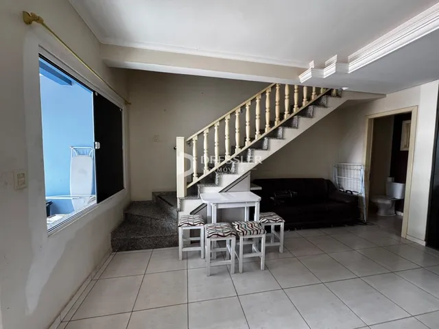 Sala de estar com escadaria e janela de vista.