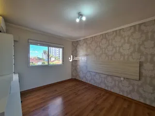 Quarto com piso de madeira e parede com papel de parede na Lajeado.