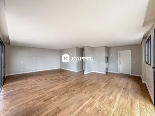 Sala ampla com piso de madeira e paredes claras em um imóvel em Lajeado.