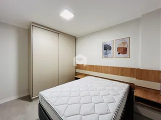 Quarto com armário embutido e cabeceira de madeira.