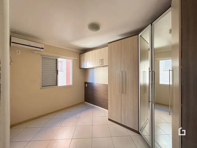 Interior de um corredor com piso de cerâmica e armários de madeira.
