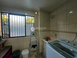 Foto de um ambiente interno com revestimento cerâmico e máquina de lavar roupa.