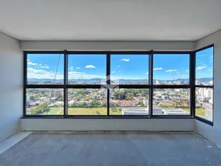 Vista de uma sala de imóvel em Lajeado com grandes janelas.