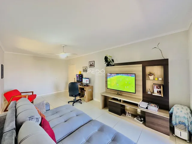 Sala de estar com sofá e painel de TV em um apartamento.