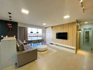 Sala de estar moderna com piso claro e painel de madeira.
