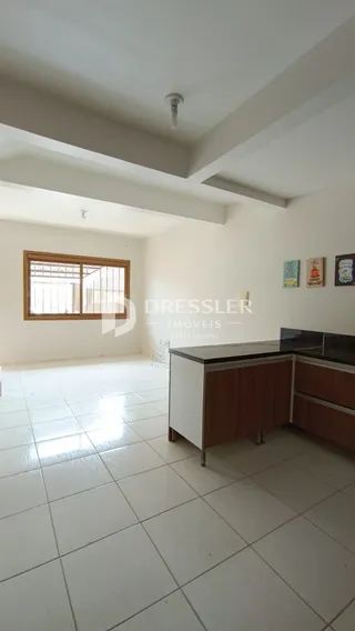 Imagem de um ambiente interno claro com piso de cerâmica e paredes brancas.