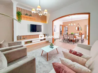 Sala de estar com sofá e painel de madeira na residência.