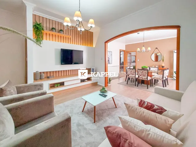 Sala de estar com sofá e painel de madeira na residência.