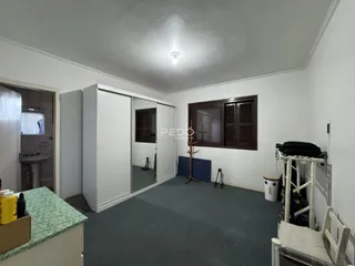 Ambiente interno de uma sala com paredes brancas e piso cinza.