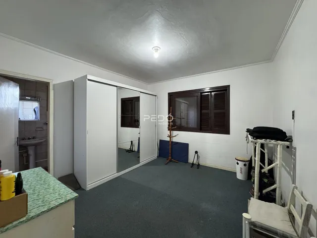Ambiente interno de uma sala com paredes brancas e piso cinza.