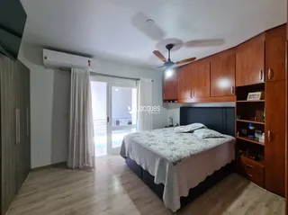 Quarto com cama e armário de madeira no interior da residência.