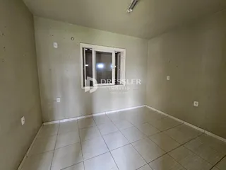 Interior de um ambiente com piso de cerâmica e paredes claras.
